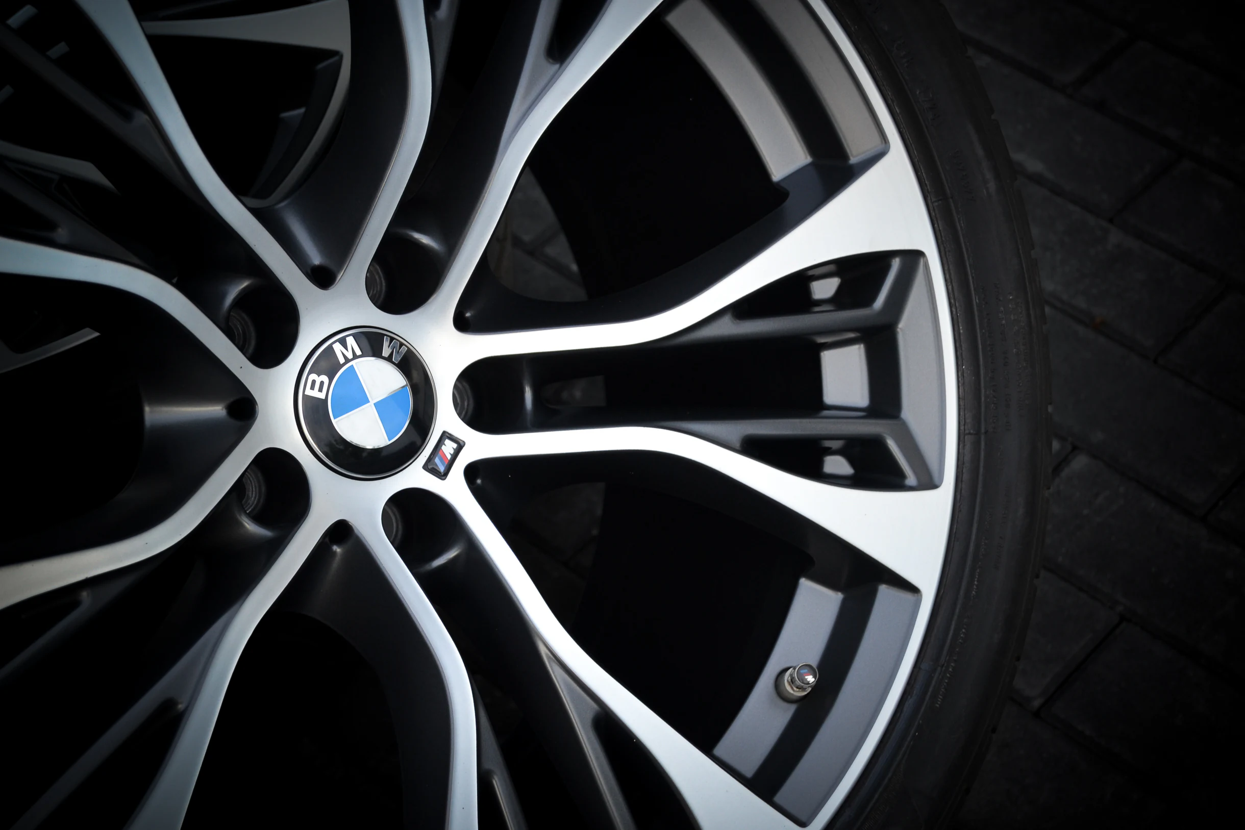 Nahaufnahme der hellen Speichenfront und dunklen Zwischenräume einer BMW-Felge bei AT Plus.